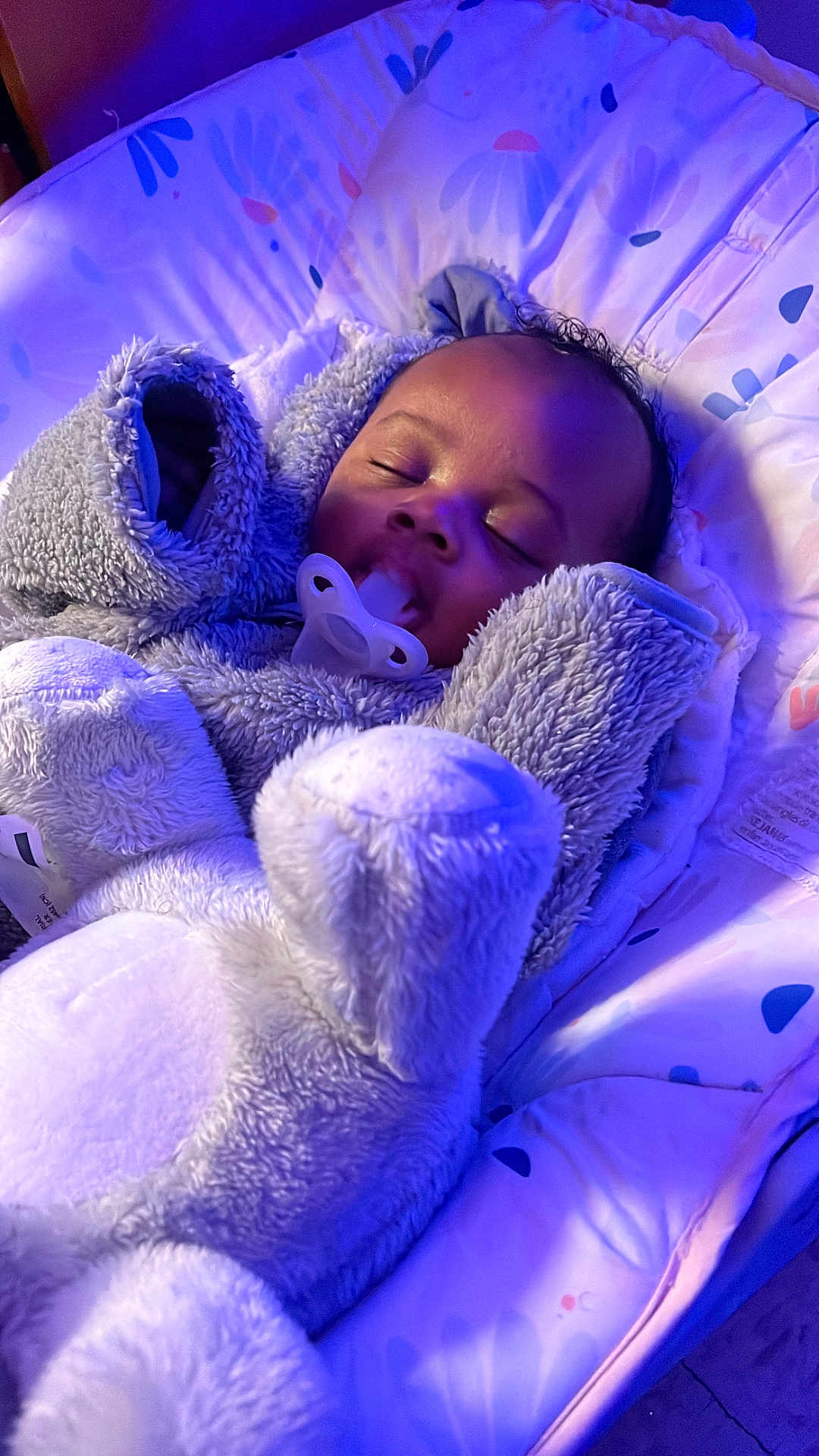 Cylas is registered to the contest to win money with this photo: baby, sleeping, pacifier, onesie, plush, cushion, infant, cozy, child, indoor, soft, cute, comfort, peaceful, face, head, clothing, rest, purple_light, bed