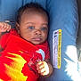 baby, infant, car_seat, red_onesie, blue_cushion, child, cute, portrait, indoors, person, seatbelt, young, skin, hand, face, expression, clothing, sunlight, relaxing, seat
