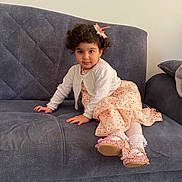 Lina a rejoint le concours — aidez-le/la à gagner de superbes lots ! blue_couch, cardigan, carpet, child, couch, curly_hair, cute, dress, floral_pattern, furniture, hair_clip, home, indoor, living_room, person, portrait, shoes, smiling, socks, young_child