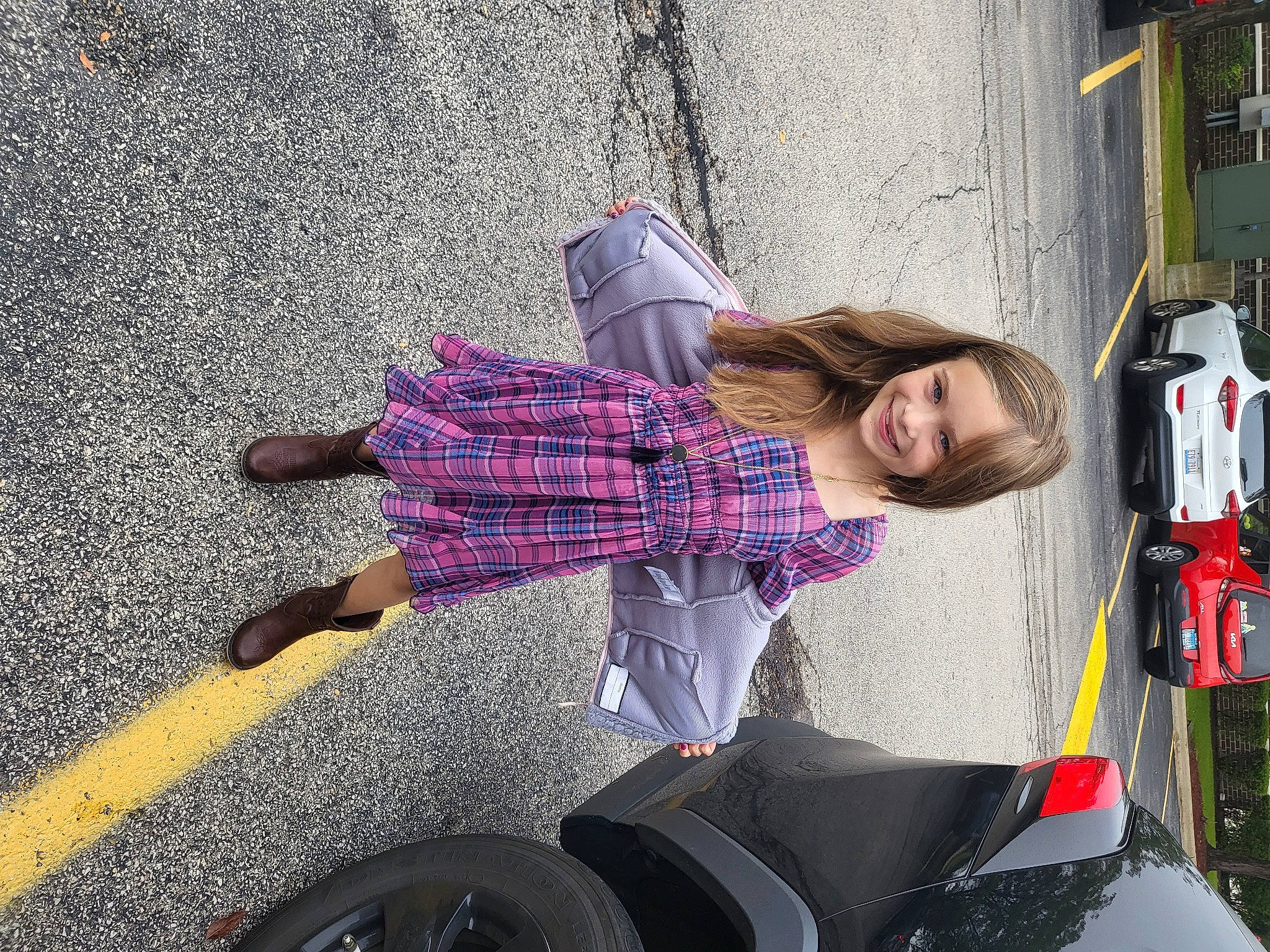 Sophia is registered to the contest to win money with this photo: asphalt, automotive_design, automotive_exterior, automotive_lighting, automotive_tire, automotive_wheel_system, car, eyewear, human_leg, joy, motor_vehicle, pattern, person, plaid, road, road_surface, shoe, sidewalk, smile, sneakers