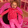 Ocean Rae is registered to the contest to win money with this photo: toddler, child, bean_bag_chair, barbie, pink, dollhouse, toy, indoor, carpet, smiling, curly_hair, socks, sitting, furniture, playroom, decor, lamp, plant, shelf, portrait