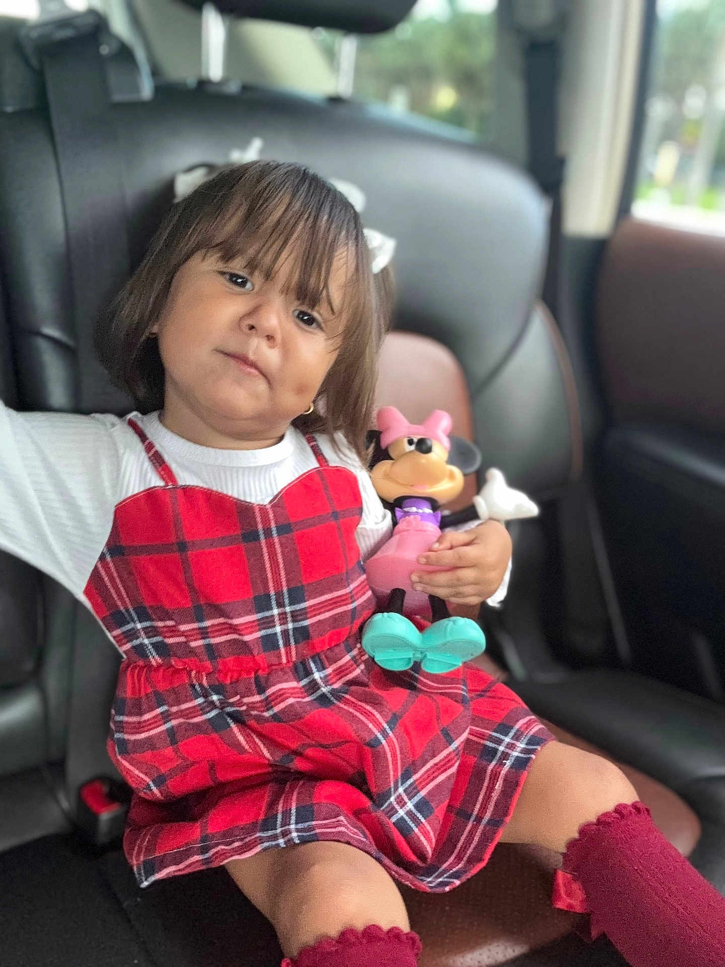 Alessia joined the competition — help win amazing prizes! child, girl, car_seat, plaid_dress, toy, minnie_mouse, red, maroon_socks, hair_bow, indoor, seat, window, toy_figure, portrait, cute, kid, young_child, car_interior, sitting, person