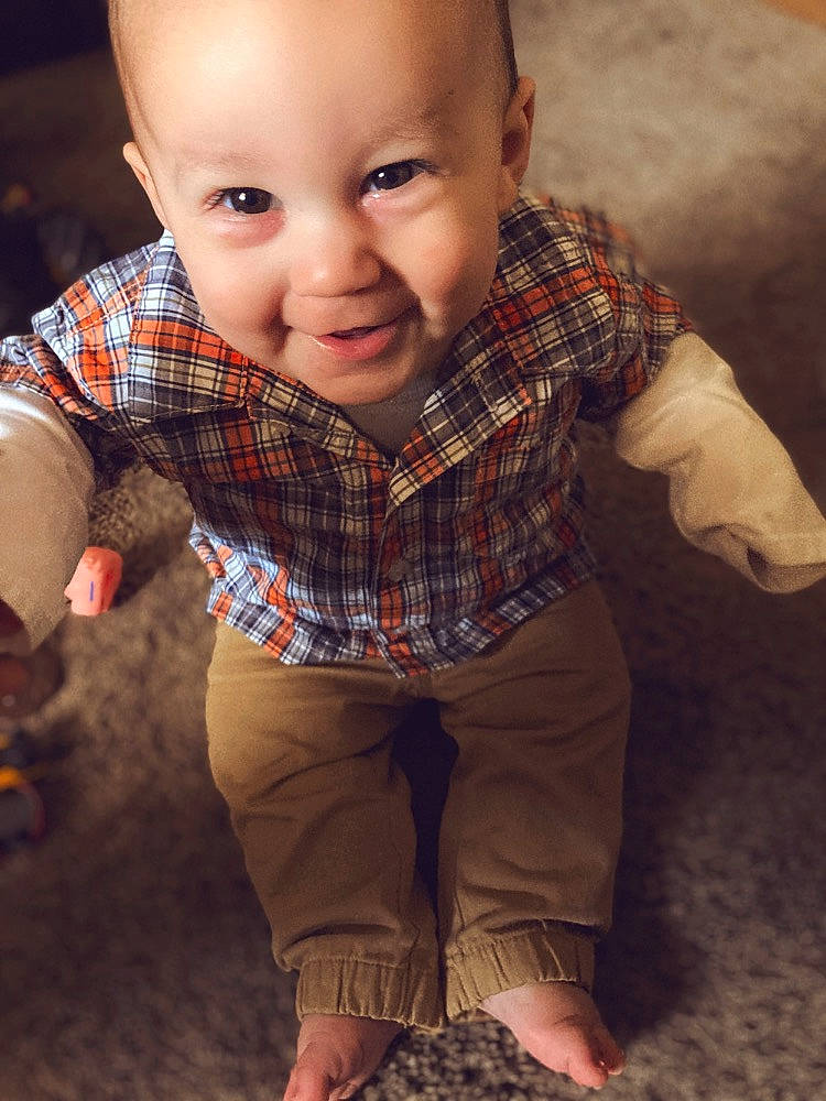 Chevy is registered to the contest to win money with this photo: cheek, eye, face, facial_expression, flash_photography, hairstyle, hand, head, human_body, leg, lip, mouth, nose, outerwear, person, plant, skin, sleeve, smile, tartan