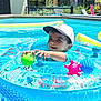 toddler, child, pool, inflatable_ring, ball, water, cap, smile, outdoor, sunny, blue, toy, play, summer, happy, person, floating, backyard, garden, swimming