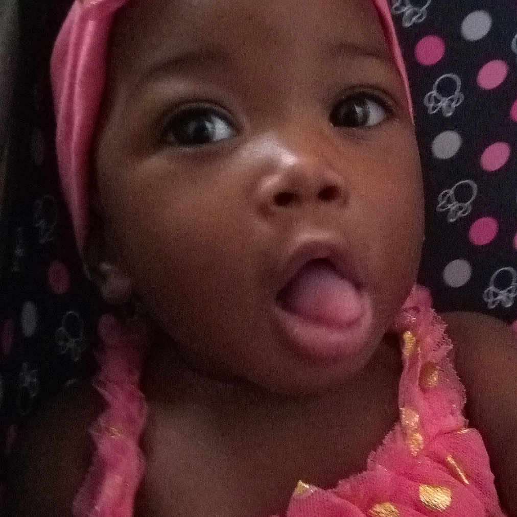 Genesis joined the competition — help win amazing prizes! baby, girl, child, pink_dress, headband, polka_dots, gold, tongue_out, curious, face, portrait, closeup, cute, infant, smiling, happy, indoors, fabric, pattern, person