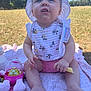 baby, child, outdoor, sunhat, bib, blanket, toy, grass, snack, food, bottle, feet, hands, face, summer, park, cute, infant, sitting, daylight