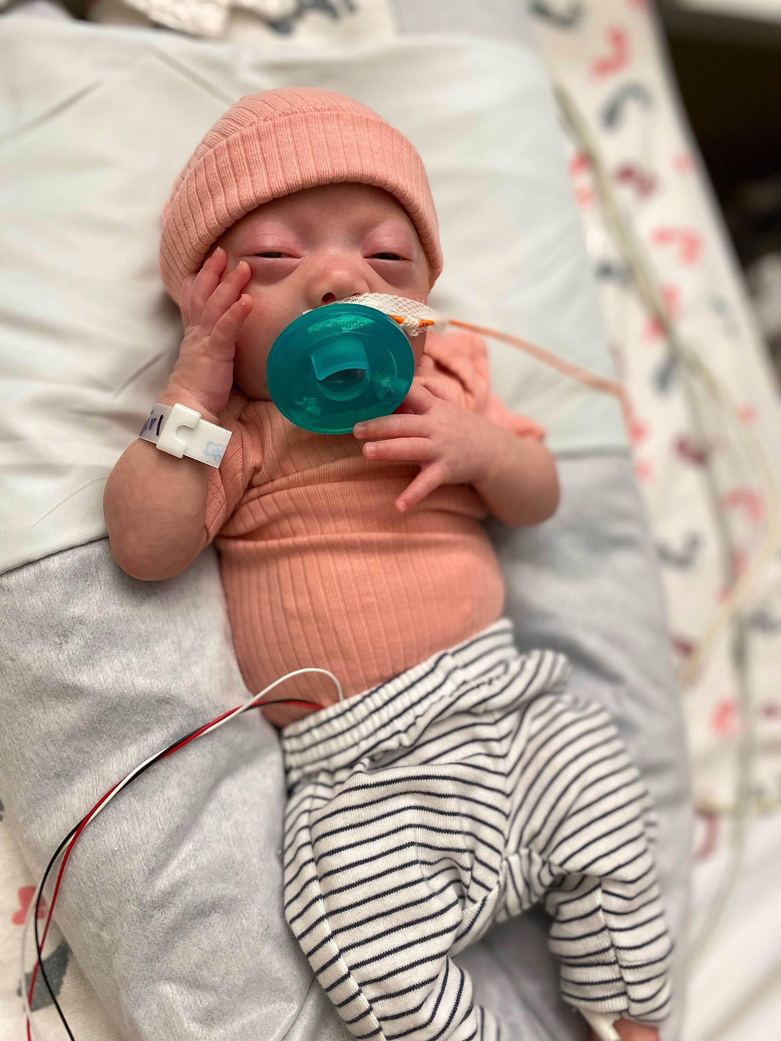 Kahlani is registered to the contest to win money with this photo: abdomen, arm, baby, baby_products, baby_sleeping, baby_toddler_clothing, cap, child, comfort, hand, happy, linens, pattern, person, pink, sitting, skin, sleeve, t_shirt, textile