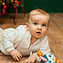 Stefan participe au concours pour gagner de l'argent avec cette photo : baby, child, toy, floor, wooden_floor, blue_eyes, white_clothing, indoor, curious, playing, infant, holiday, christmas_tree, blurred_background, cute, hands, face, light, soft_lighting, portrait