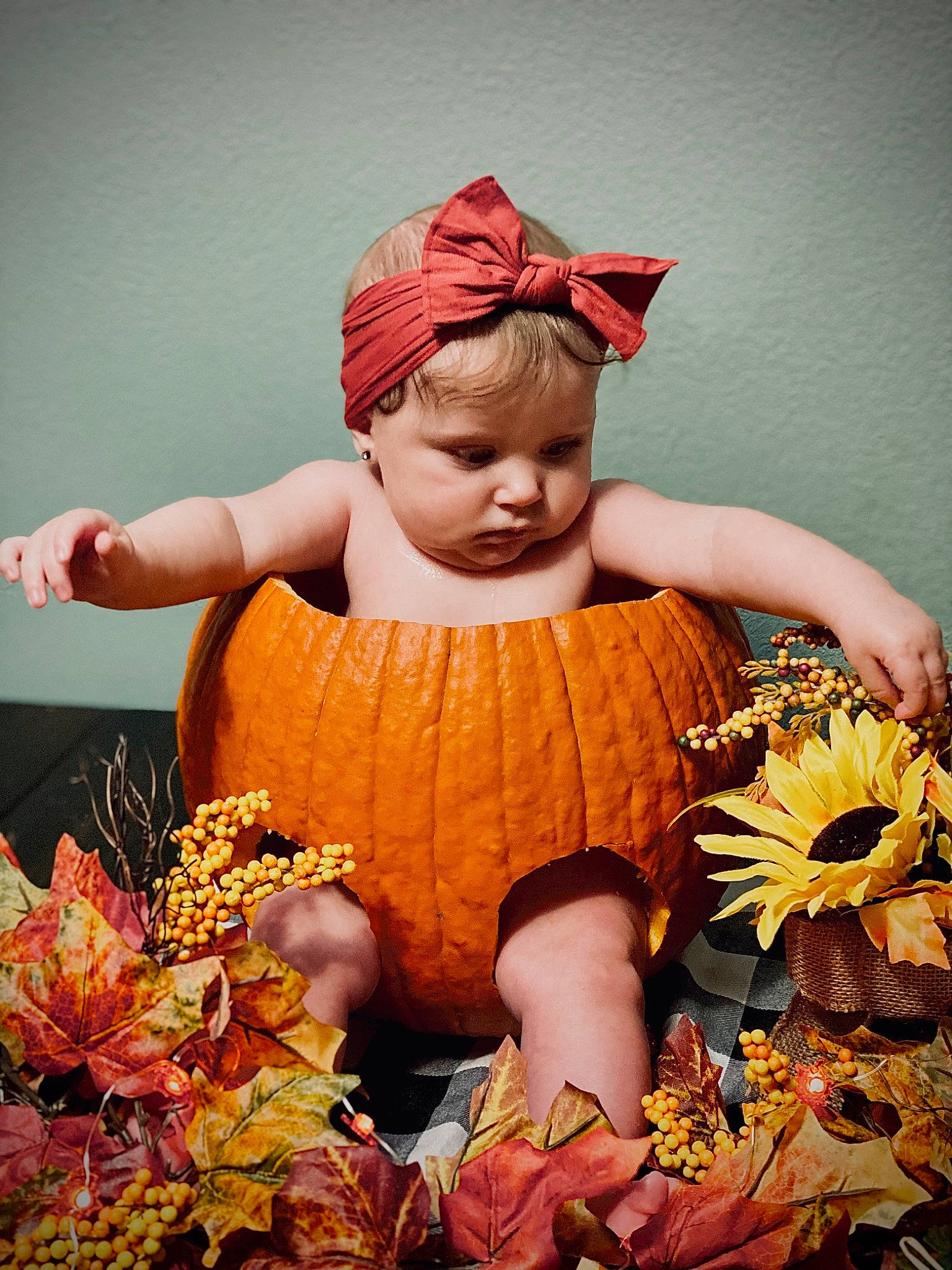 Henley is registered to the contest to win money with this photo: calabaza, child, dress, event, eye, fashion_accessory, flash_photography, flower, gourd, grass, happy, headpiece, headwear, human_body, orange, people_in_nature, person, plant, pumpkin, toddler