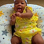 Noa joined the competition — help win amazing prizes! baby, infant, yellow_clothing, bow_headband, smiling, tongue_out, star_pattern, pillow, carpet, floor, playful, cute, child, indoors, happy, closeup, person, lying_down, soft_lighting, floral_pattern