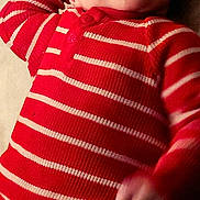 Waylen joined the competition — help win amazing prizes! baby, child, smiling, lying_down, red_clothing, striped_clothing, onesie, happy, face, infant, cute, portrait, skin, hand, head, eyes, expression, indoor, soft_lighting, cozy