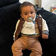Soën a rejoint le concours — aidez-le/la à gagner de superbes lots ! baby, child, pacifier, couch, jacket, pants, bib, indoor, unicorn, decor, sitting, face, person, cozy, furniture, cute, expression, clothing, sock, texture