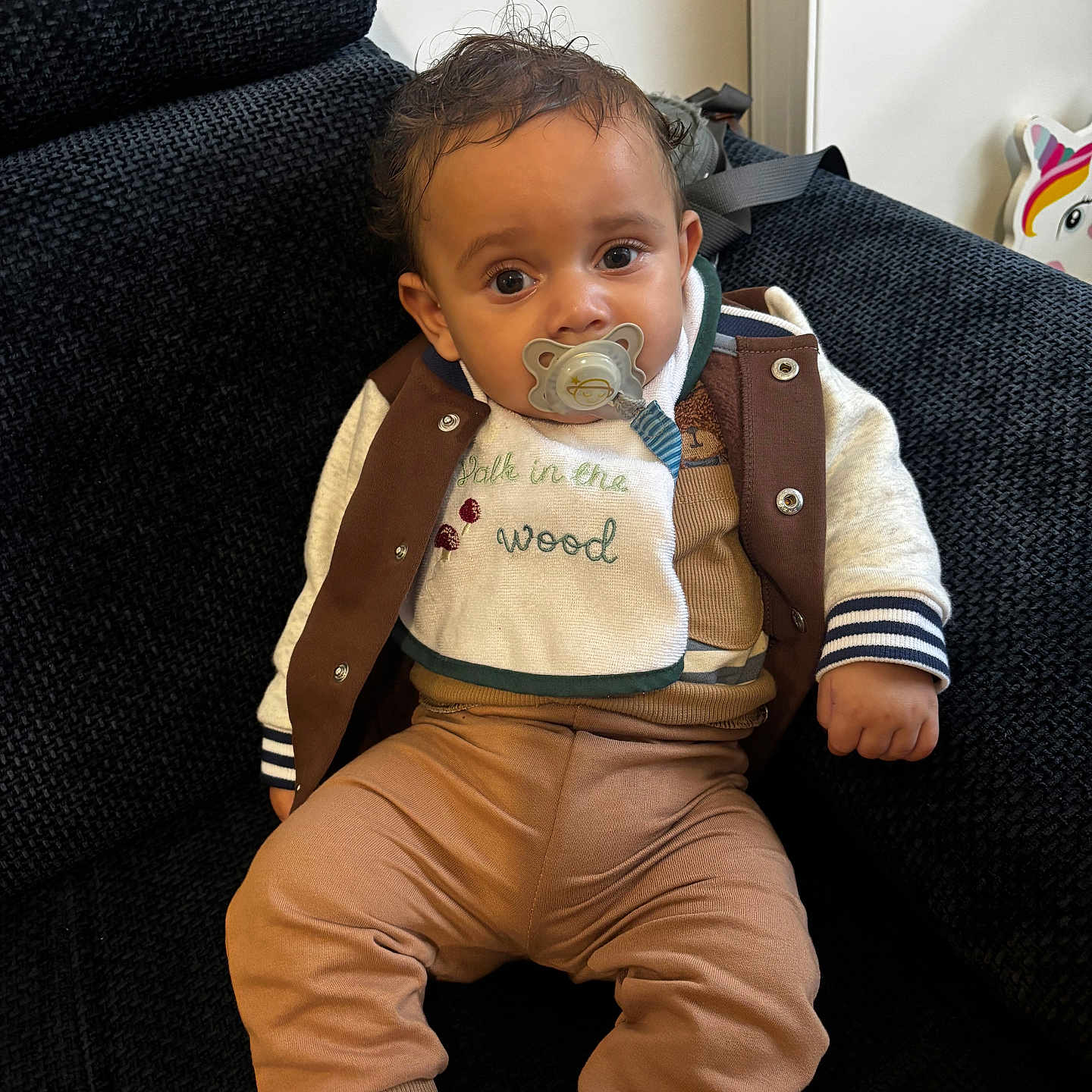 Soën a rejoint le concours — aidez-le/la à gagner de superbes lots ! baby, child, pacifier, couch, jacket, pants, bib, indoor, unicorn, decor, sitting, face, person, cozy, furniture, cute, expression, clothing, sock, texture