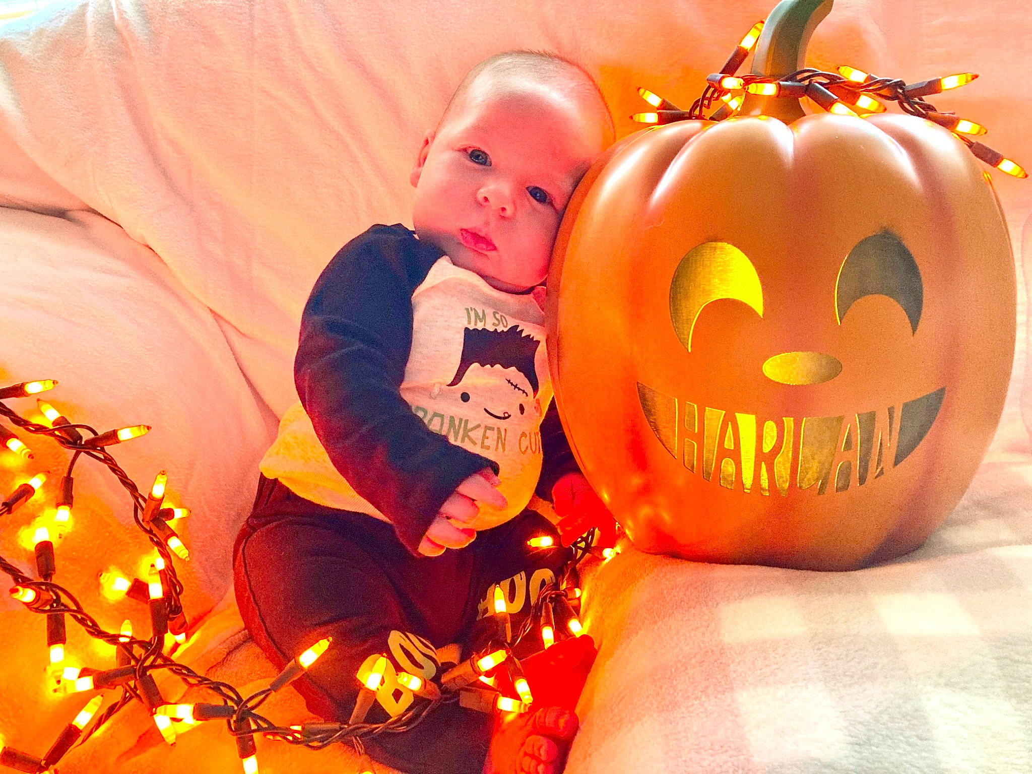 Harlan is registered to the contest to win money with this photo: baby, baby_toddler_clothing, calabaza, comfort, eye, fruit, grass, hair, happy, head, human_body, natural_foods, orange, people_in_nature, person, plant, pumpkin, smile, toddler, vegetable