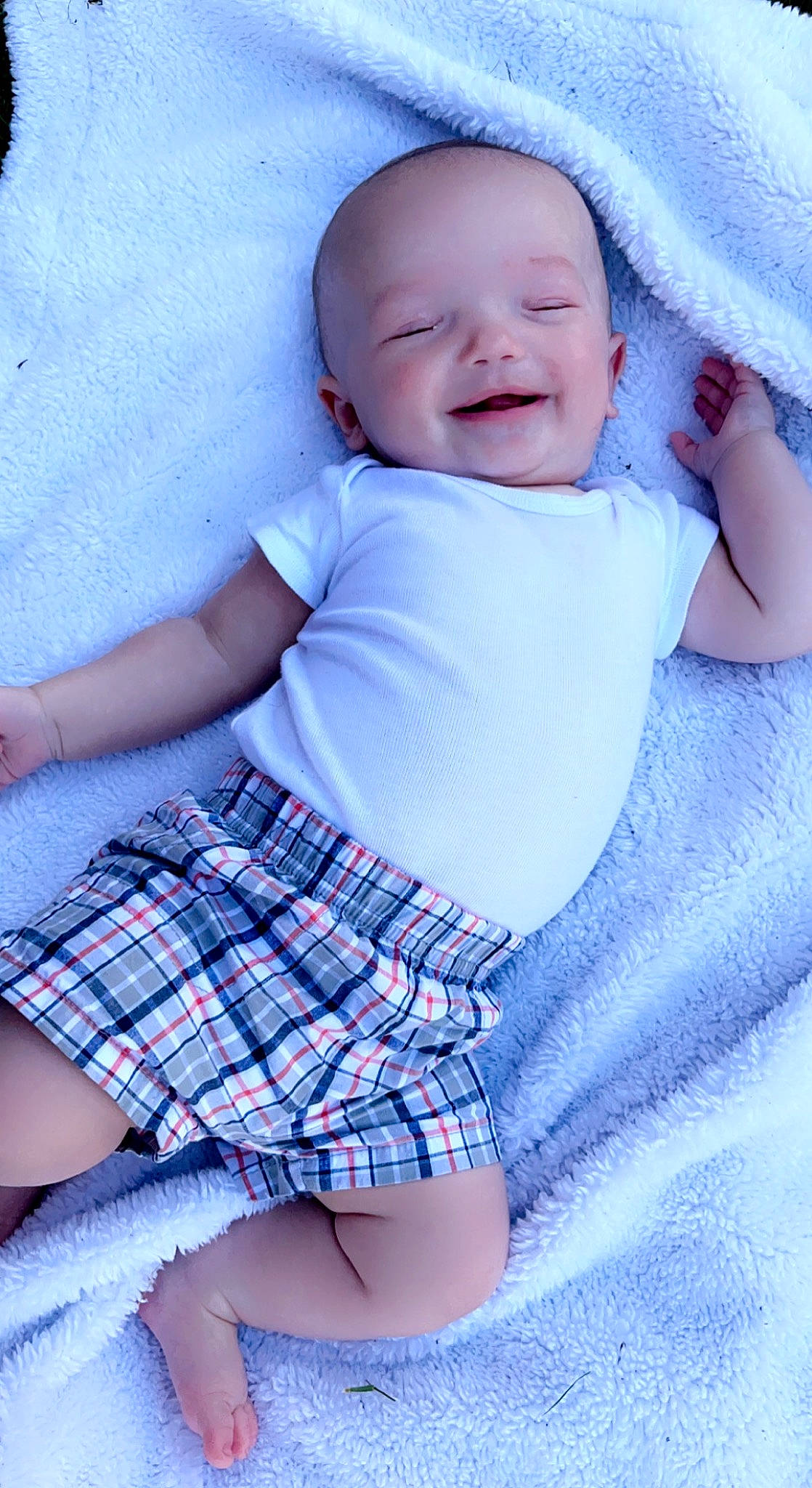 Gordon is registered to the contest to win money with this photo: azure, baby, baby_toddler_clothing, blue, facial_expression, finger, hand, happy, human, lip, organ, person, plaid, purple, skin, sleeve, smile, standing, tartan, textile