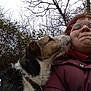 affection, animal, bare_branches, canine, closeup, cloudy_sky, companion, dog, facial_expression, glasses, jacket, licking, nature, outdoor, person, pet, portrait, scarf, tree, winter_clothing