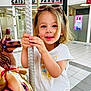 Chloé participe au concours pour gagner de l'argent avec cette photo : child, carousel, horse, indoor, shopping_mall, bank, tiled_floor, blonde_hair, sunglasses, white_tshirt, smiling, playing, pole, fun, portrait, happy, person, young_child, casual_clothing, daylight