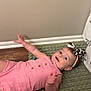 baby, child, pink_romper, headband, leopard_print, green_rug, wooden_floor, wall, flooring, infant, cute, smiling, lying_down, indoor, earrings, happy, person, toddler, portrait, casual_clothing