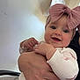 Emberlynn is registered to the contest to win money with this photo: baby, child, smile, headband, pink_bow, hand, arm, clothing, long_sleeve, pants, person, indoor, wall, paper, chair, holding, happy, cute, face, portrait