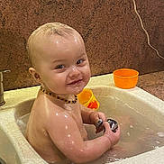 Eliott a rejoint le concours — aidez-le/la à gagner de superbes lots ! baby, bath, sink, water, wet, smile, child, orange_cup, kitchen, play, happy, portrait, cute, skin, head, hand, necklace, indoor, toddler, faucet