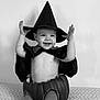 Jade participe au concours pour gagner de l'argent avec cette photo : child, toddler, smile, hat, witch, costume, pumpkin, black_and_white, cape, happy, playful, legs, sitting, indoors, fabric, face, cute, holiday, festive, portrait