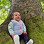 Jade a rejoint le concours — aidez-le/la à gagner de superbes lots ! toddler, child, tree, moss, forest, nature, outdoor, greenery, leaves, roots, clothing, vest, pants, shoes, happy, smiling, person, sitting, daylight, casual
