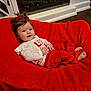 baby, child, smiling, red_blanket, white_shirt, red_pants, hair_bows, pony_tail, happy, cute, infant, indoors, floor, plush, cozy, relaxed, person, portrait, clothing, feet
