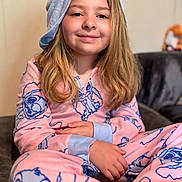 Harley joined the competition — help win amazing prizes! child, pajamas, pink, blue, hood, cartoon_characters, smiling, long_hair, couch, indoor, cozy, comfortable, seated, portrait, relaxed, young, cute, home, casual, happy