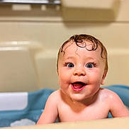 Niko is registered to the contest to win money with this photo: baby, bathtub, bath, child, cute, face, happy, indoors, infant, joy, kid, person, portrait, skin, smile, toddler, water, wet, young, curly_hair