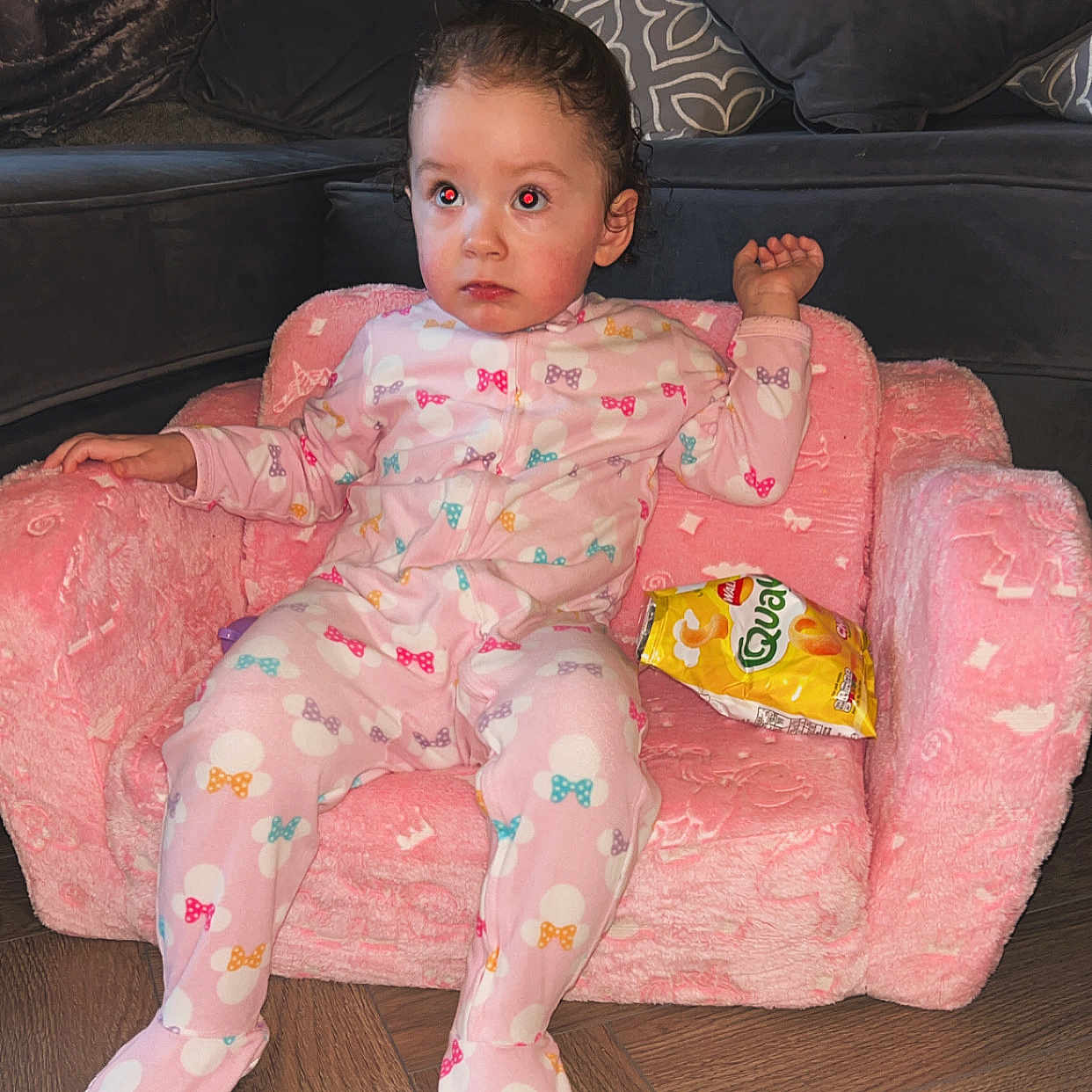 Lilli is registered to the contest to win money with this photo: armchair, baby, bodypart, chair, clothing, couch, cushion, face, finger, formalwear, furniture, hand, head, homedecor, pajamas, person, photography, portrait, sitting, suit