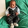 baby, child, tuxedo, clothing, socks, blanket, green_blanket, white_shirt, black_pants, infant, portrait, sitting, indoor, cute, young_child, cozy, soft_texture, face, person, expression