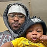 Kasai joined the competition — help win amazing prizes! baby, adult, beanie, glasses, hoodie, yellow_shirt, indoor, selfie, portrait, face, child, person, casual_clothing, matching_hats, cute, infant, hand, foot, relaxed, cozy