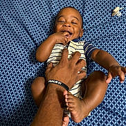 Kasai joined the competition — help win amazing prizes! baby, background, bed, blue_sheet, child, fingers, foot, hand, happy, infant, joyful, laughing, onesie, patterned_sheet, person, playing, skin, smiling, striped_clothing, tickling
