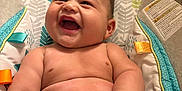 Ryker is registered to the contest to win money with this photo: baby, laughing, chubby, diaper, infant, cushion, seat, colorful, pattern, leaf_pattern, happy, skin, hand, arm, torso, indoor, child, cute, smile, portrait