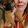 woman, puppy, dog, pet, face, portrait, smile, orange_hoodie, fur, hand, indoor, cute, animal, closeup, brown_eyes, long_hair, friendship, warm, love, cozy