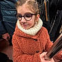 Aureline a rejoint le concours — aidez-le/la à gagner de superbes lots ! child, glasses, braided_hair, orange_coat, scarf, hand, metal_pole, public_transport, backpack, adult, indoor, winter_clothing, portrait, casual, holding, person, face, young, warm, candid