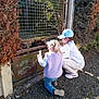 Aureline a rejoint le concours — aidez-le/la à gagner de superbes lots ! children, kids, gate, metal_gate, rust, outdoor, sunlight, gravel, bushes, curious, crouching, cap, sneakers, jeans, vest, long_sleeve, nature, daylight, playful, exploring