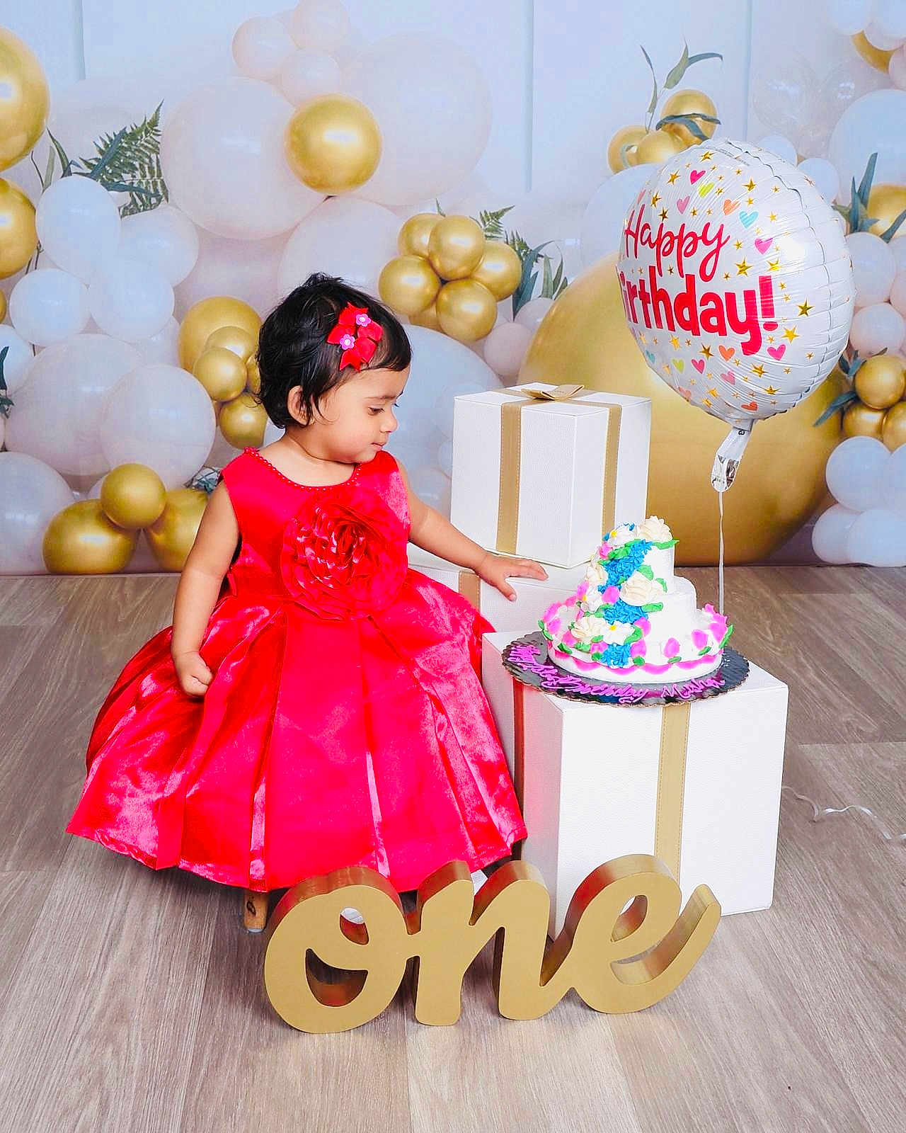 Misha is registered to the contest to win money with this photo: toddler, birthday, red_dress, cake, balloons, gift_boxes, celebration, floor, flower_hairclip, holiday, party, child, one_year, decorations, happy_birthday, indoor, person, colorful, smiling, festive
