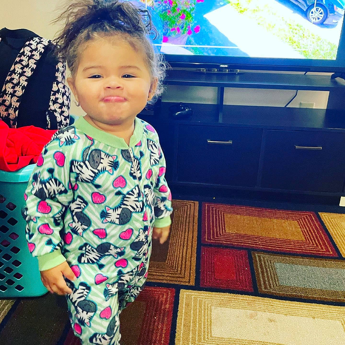 Kaliyah is registered to the contest to win money with this photo: baby, baby_toddler_clothing, blue, cool, eye, flooring, fun, green, happy, human_body, person, photograph, pink, sleeve, smile, snapshot, sportswear, standing, t_shirt, television