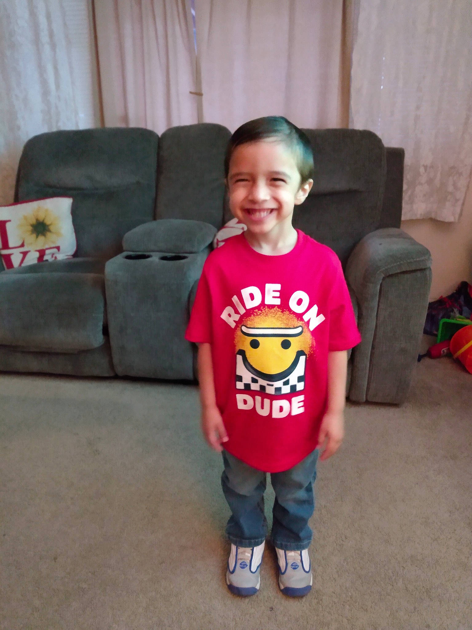 Connor is registered to the contest to win money with this photo: arm, chin, clothing, comfort, couch, eye, floor, hairstyle, happy, head, human_body, joy, leg, mammal, mouth, person, plant, shoulder, sleeve, smile