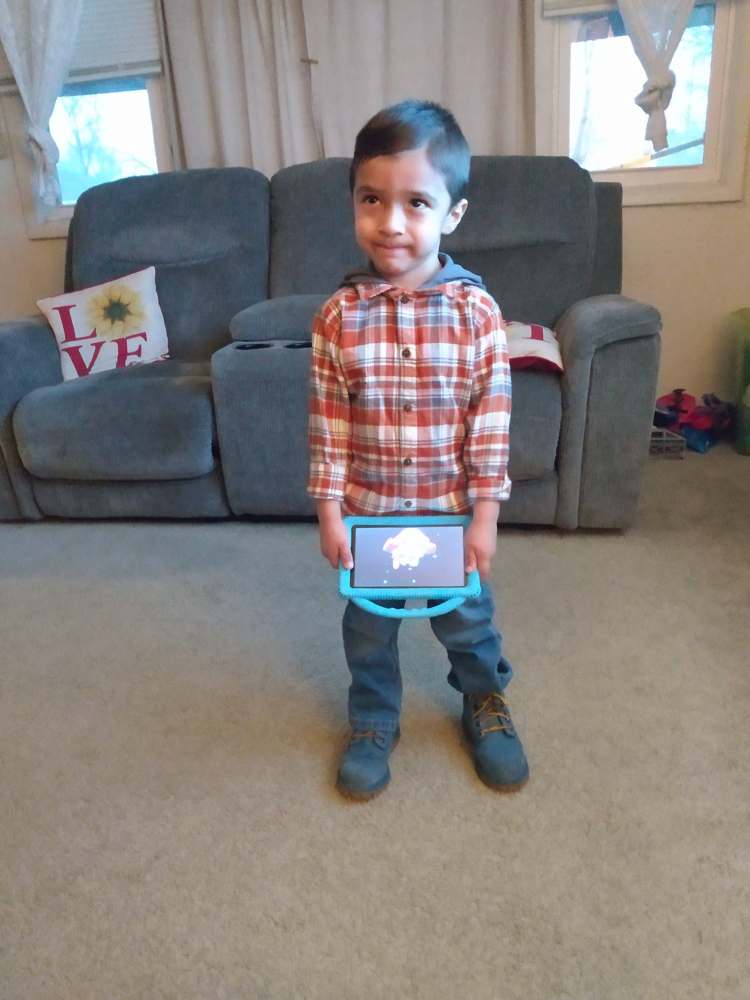 Connor joined the competition — help win amazing prizes! comfort, couch, curtain, electric_blue, face, floor, flooring, hardwood, joy, leg, living_room, pattern, person, plaid, sitting, sleeve, smile, t_shirt, tartan, textile