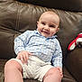 Logan is registered to the contest to win money with this photo: baby, bodypart, chair, clothing, couch, cushion, diaper, face, finger, furniture, happy, head, homedecor, pants, person, photography, portrait, shorts, sitting, smile