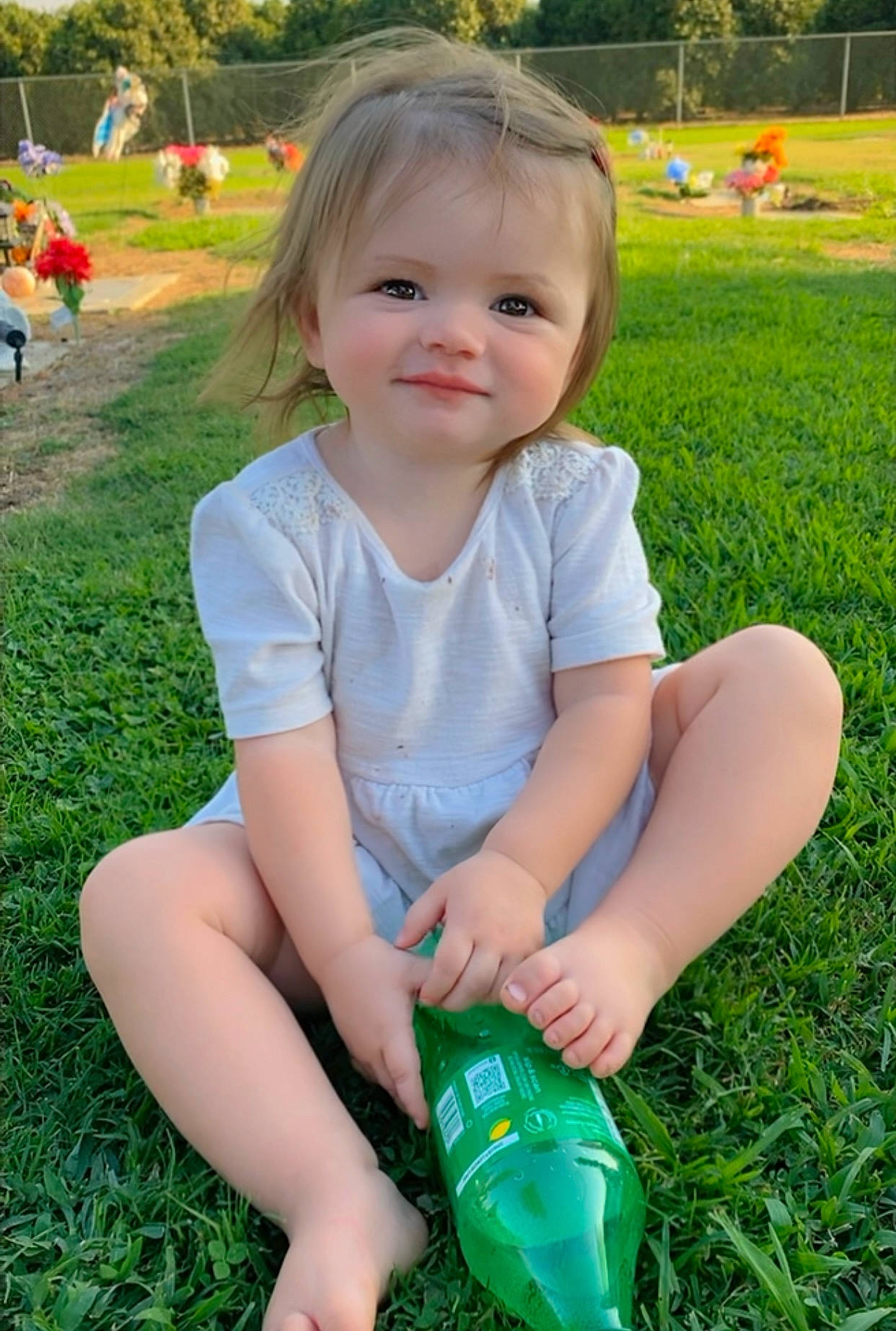 Isabella Faye is registered to the contest to win money with this photo: baby_toddler_clothing, botany, facial_expression, finger, fun, grass, green, happy, human_body, joy, leaf, leisure, people_in_nature, person, plant, plastic_bottle, recreation, skin, smile, summer