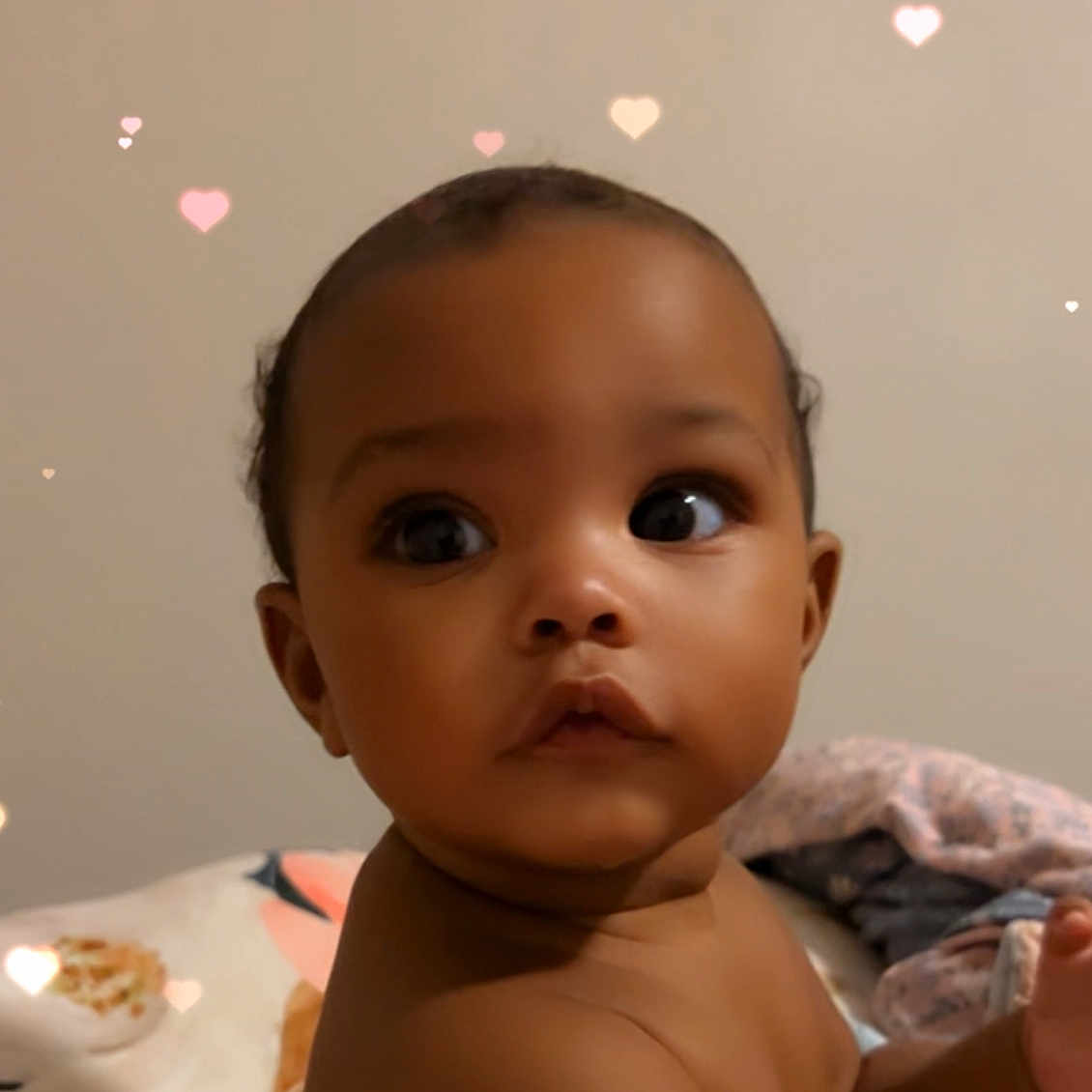 Tanjhya is registered to the contest to win money with this photo: baby, background, blanket, child, close_up, cloth, curly_hair, cute, expression, eyes, face, heart_shape, indoor, infant, light_effect, person, portrait, skin, soft_light, young