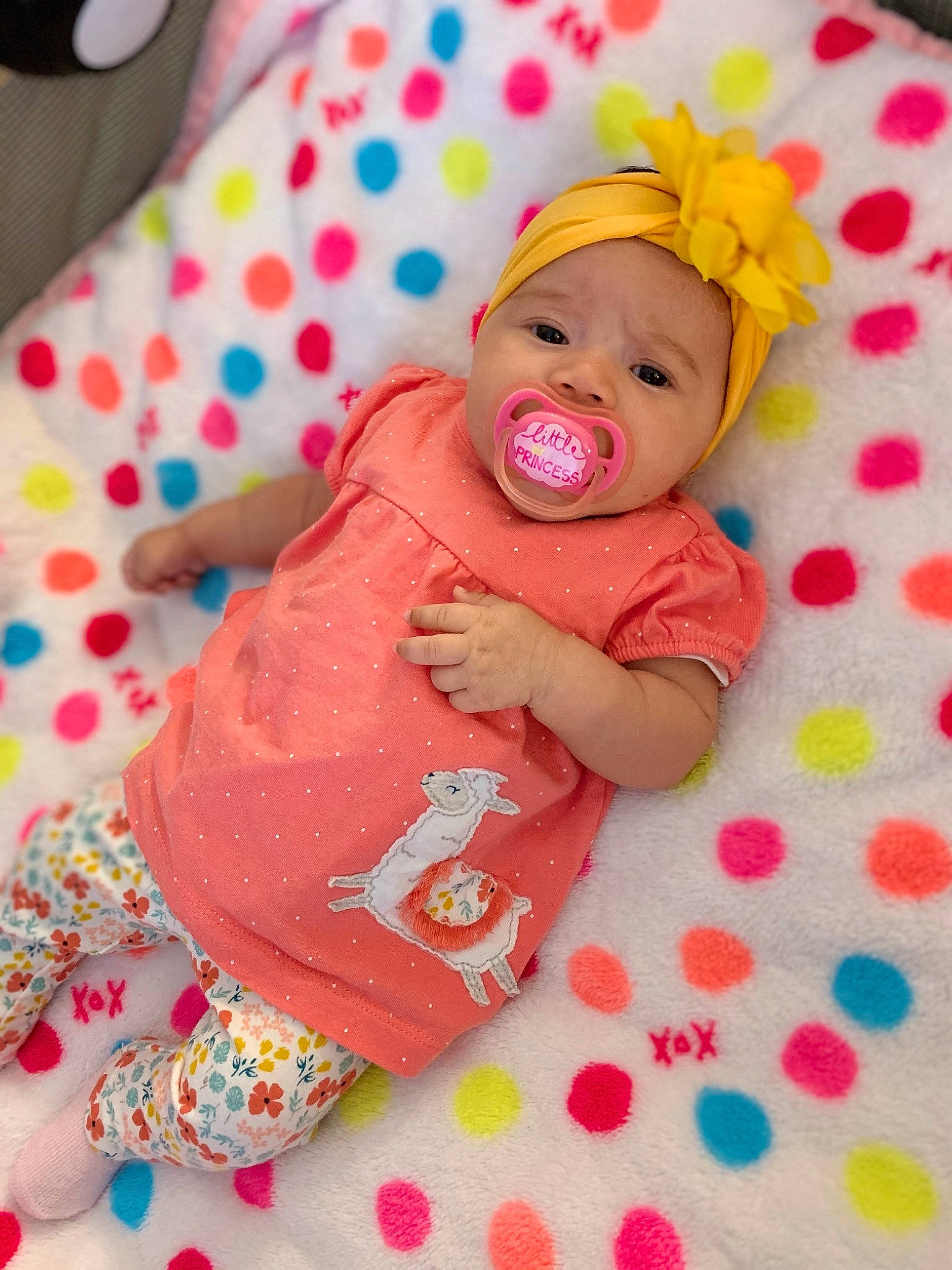 Jazlyn is registered to the contest to win money with this photo: baby, baby_toddler_clothing, cheek, child, comfort, face, fun, happy, headwear, linens, magenta, orange, pattern, person, pink, product, skin, sleeve, smile, textile