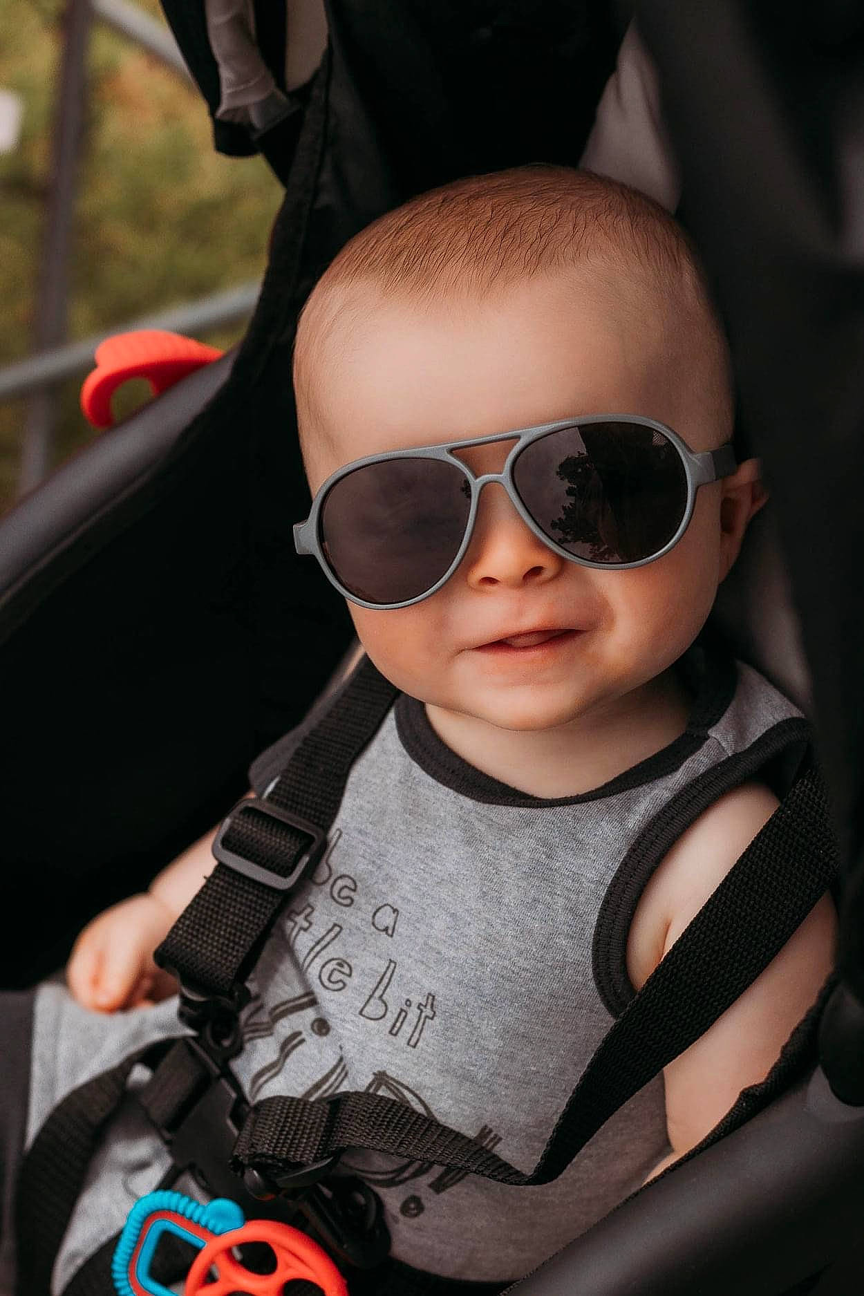 Alaric is registered to the contest to win money with this photo: auto_part, automotive_design, baby, baby_carriage, car_seat, cheek, cool, eyewear, fun, goggles, lip, mouth, nose, person, personal_protective_equipment, skin, steering_wheel, sunglasses, toddler, vehicle_door