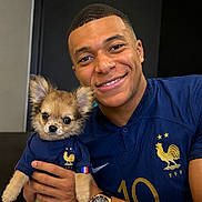 Belle a rejoint le concours — aidez-le/la à gagner de superbes lots ! man, dog, puppy, smiling, portrait, indoor, clothing, matching_outfits, sports_jersey, blue_shirt, watch, hand, cute, pet, short_hair, face, animal, friendly, close_up, happy