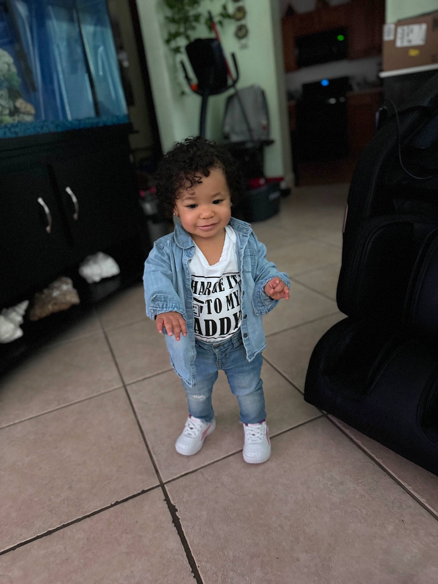 Serenity is registered to the contest to win money with this photo: baby_toddler_clothing, child, comfort, couch, eye, floor, flooring, fun, grey, hardwood, head, joy, living_room, long_sleeved_t_shirt, person, picture_frame, room, sitting, sleeve, t_shirt