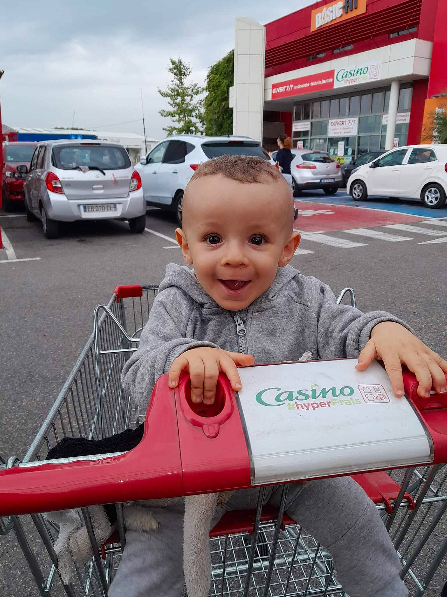 Enzo participe au concours pour gagner de l'argent avec cette photo : asphalt, automotive_design, automotive_exterior, automotive_tire, car, child, family_car, fun, happy, joy, land_vehicle, motor_vehicle, parking, person, shopping_cart, sitting, sky, smile, tire, toddler