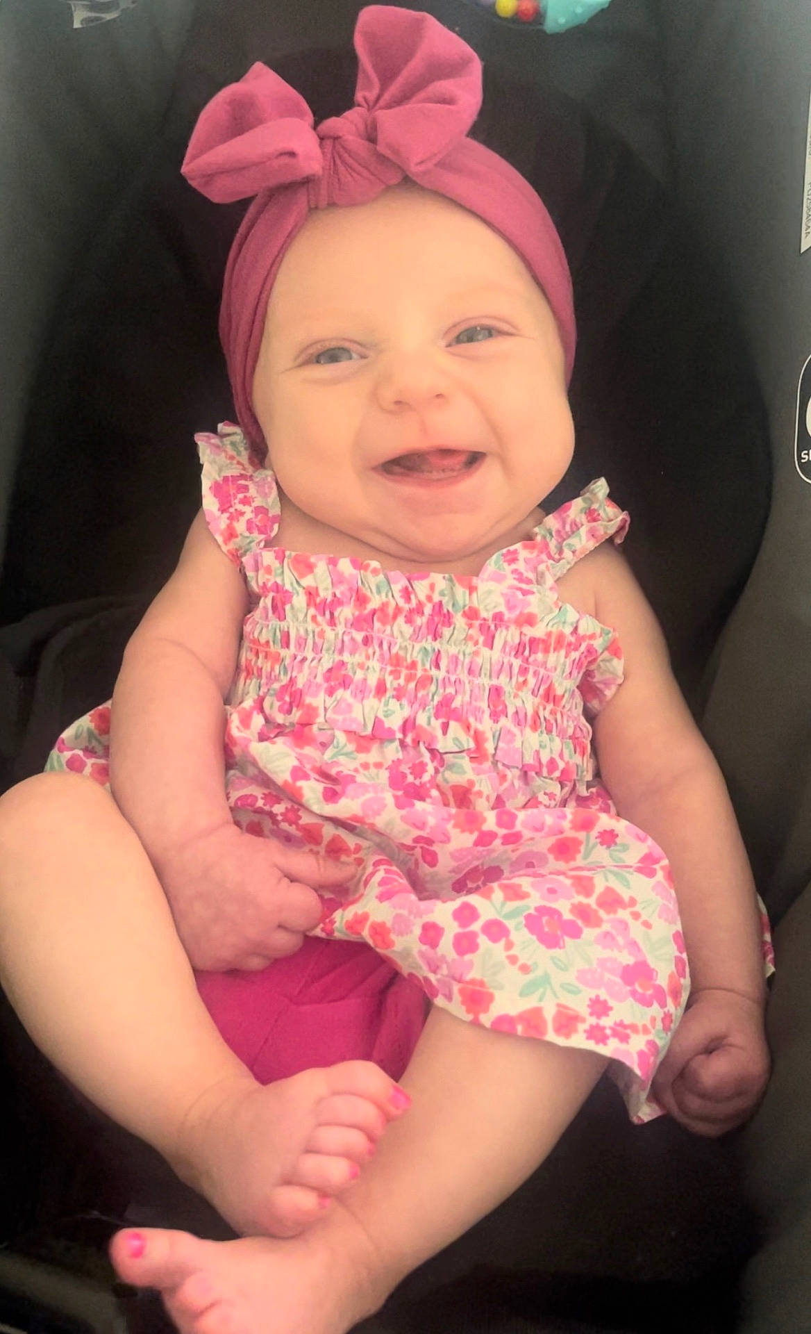 Peyton is registered to the contest to win money with this photo: accessories, baby, bodypart, bonnet, cap, clothing, dress, face, happy, hat, head, laughing, newborn, person, photography, portrait, purple, shorts, sitting, smile